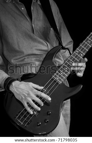 man in jeans playing electrical bass guitar, black and white