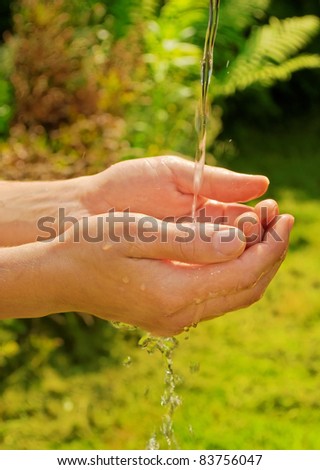hands under pouring stream of water