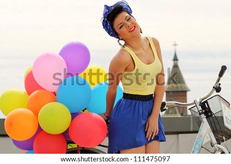 beautiful pin up with balloons on a bicycle