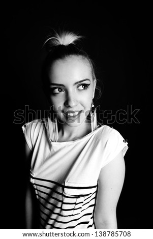 Black and white expressive portrait of a young stylish woman wearing stripes in the studio