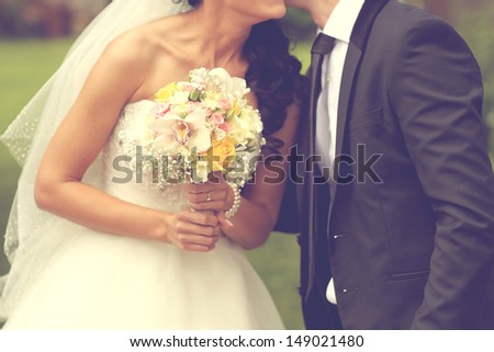 Bride kissing the groom and holding a wedding bouquet