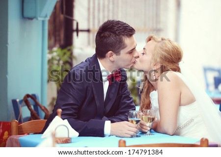 Bride kissing groom standing at the table