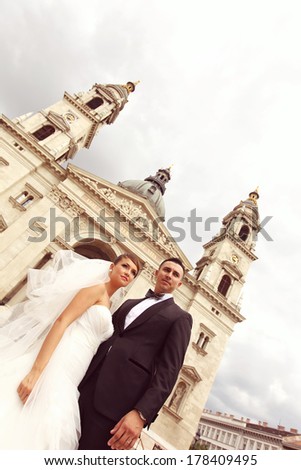 Bride and groom holding hands in front of the church