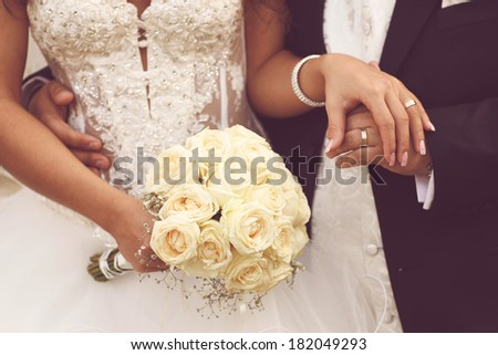 Detail of bride\'s roses bouquet and hands holding