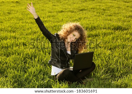 Beautiful lady with her laptop on grass