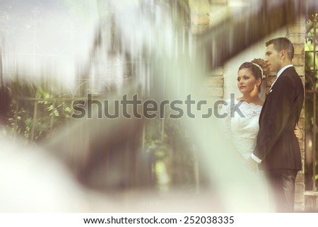 Bride and groom being seen through a parked car