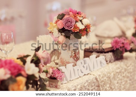 Beautifully decorated wedding table with flowers and MR&MRS letters