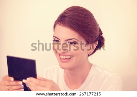 Woman looking in the mirror and laughing