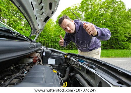 Driver showing thumb up after fixing his car
