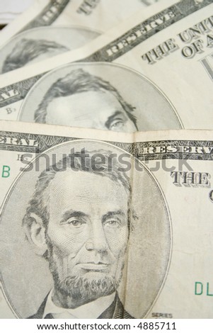 Five dollar bills close-up in disorder