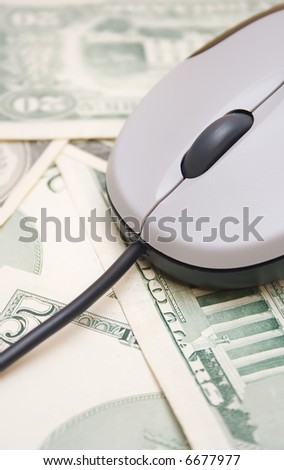 Money spend over internet, computer mouse on dollar bills background