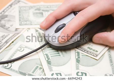 Money spend over internet, hand over computer mouse on money mouse-pad