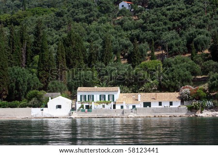 Sea coast of Corfu island. Photo made from coast line boat. Houses on shore.
