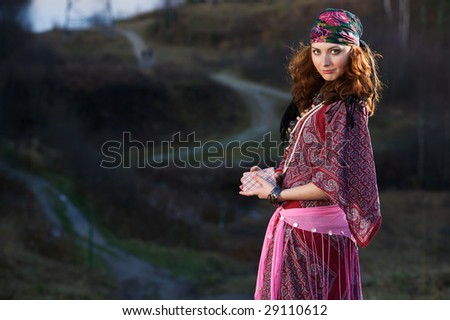 Gypsy Woman in the countryside. In hands a pack of playing cards.