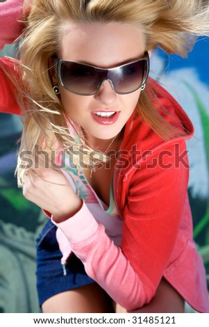 Portrait of the young woman in sun glasses. Hands in hair.