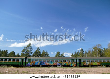 Three wagon of stationary train with graffiti.