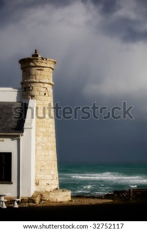 Tower on the shores of the Atlantic Ocean. South Africa. Dark sky (after the storm).