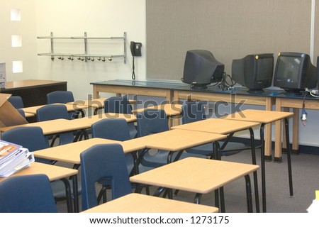 Newly constructed classroom with desks, tables, and computer monitors wait to be organized
