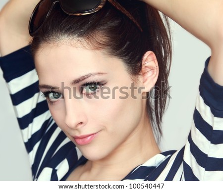 Pretty girl  with green eyes and hands behind the head. With sunglasses on the head and summer bright dress looking happy