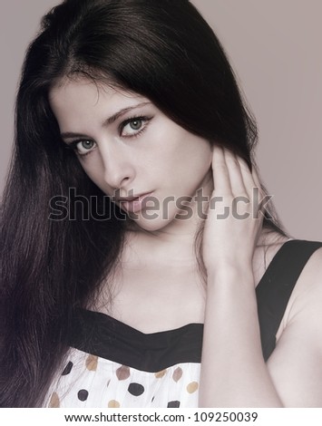 Beautiful natural girl holding long hair and looking calm. Closeup art portrait