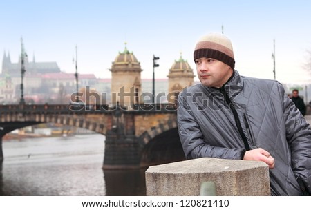 Thinking man looking on Prague bridge spring background under blue sky