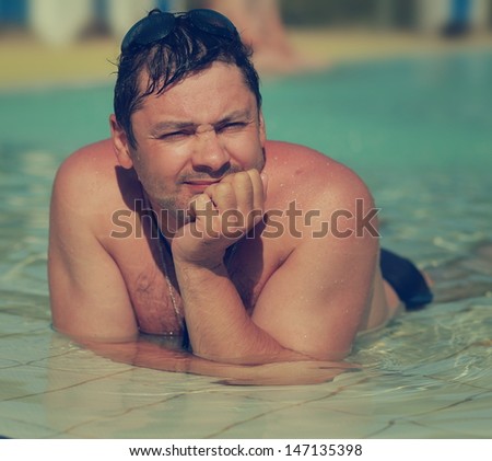 Man sunbathing in swimming pool. Closeup vintage portrait