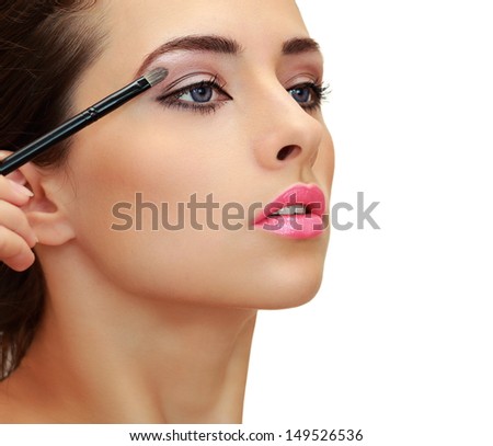 Beautiful woman applying the brush luxury eyeshadows. Closeup isolated profile