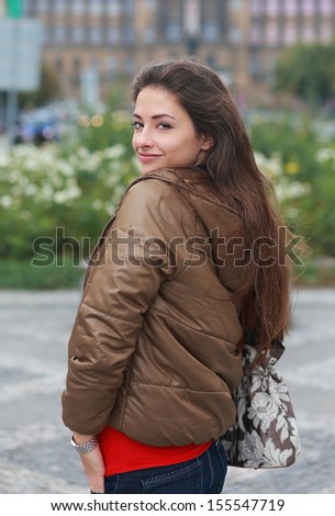 Beautiful sexy woman posing in brown jacket outdoors street background