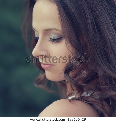 Beautiful profile of romantic girl face looking down outdoors. Closeup portrait