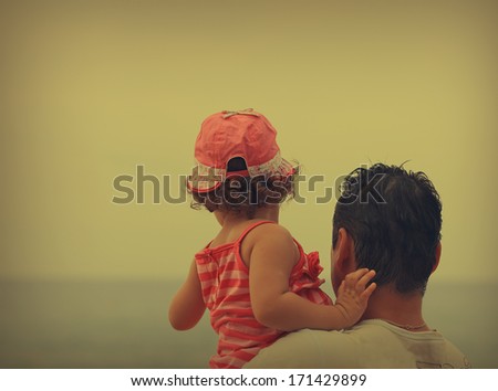 Father and kid looking on the beach. Vintage portrait