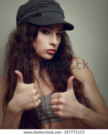 Happy joy teen girl in fashion cap with thumb up sign. Closeup vintage portrait