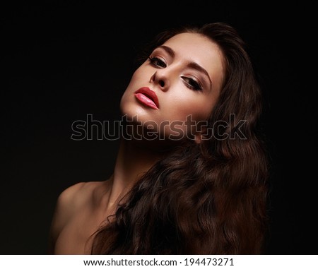 Beautiful makeup woman with long curly hair on black background