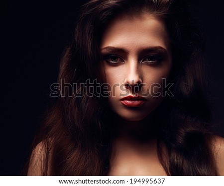 Sexy female model face with long hair. Dramatic light. Closeup