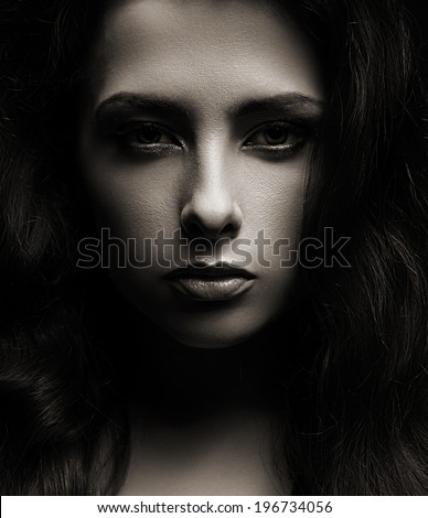 Closeup portrait of beautiful woman face on dark shadows background