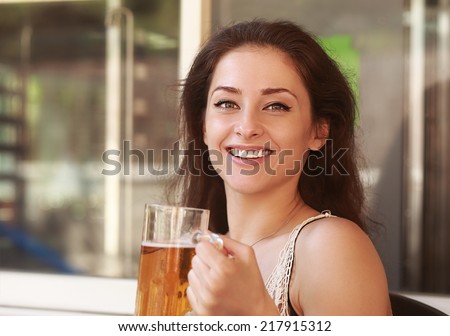 Laughing woman drinking lager beer in bar