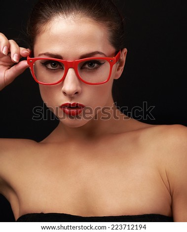 Sexy makeup woman in red eyes glasses looking. Closeup on black background