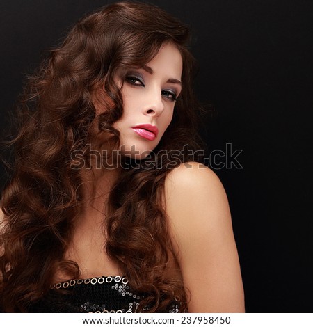 Beautiful fashion female model with long brown hair looking sexy on black background