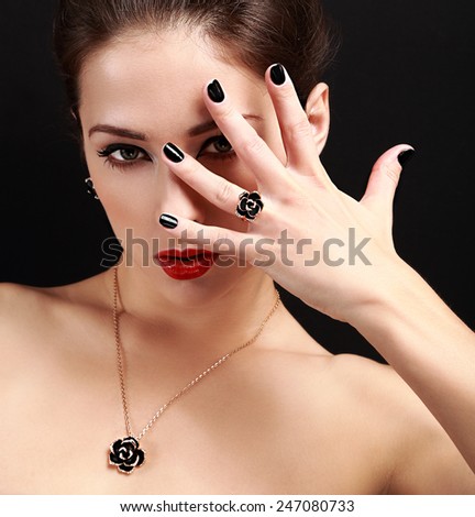 Sexy makeup model with black nails gloss looking. Closeup portrait on black background