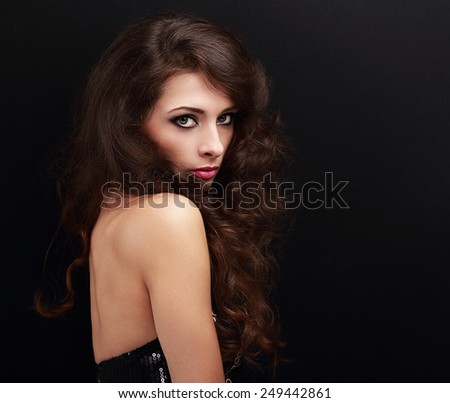 Beautiful female model looking sexy with smoky eyes makeup on black background