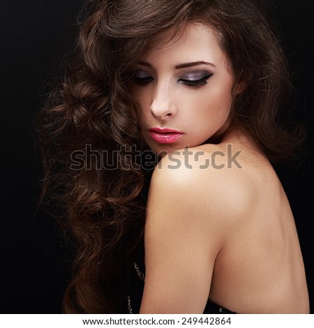 Beautiful bright makeup woman with curly brown hair looking down. Closeup portrait