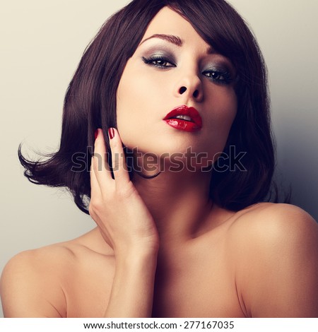 Hot sexy makeup model with short black hair style and red lipstick. Vintage closeup portrait
