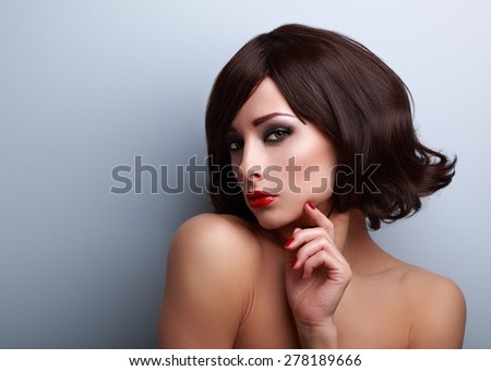 Beautiful makeup woman with short hairstyle and red nails gloss with empty copy space on blue background