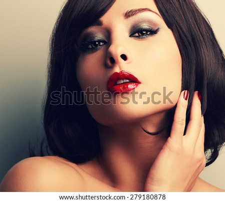 Bright makeup red lips woman with desire look and smokey eyes. Closeup vintage color portrait