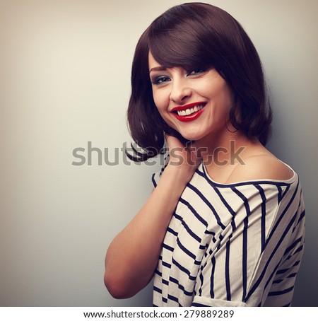 Beautiful smiling young woman with short hair style on blue background. Vintage closeup portrait