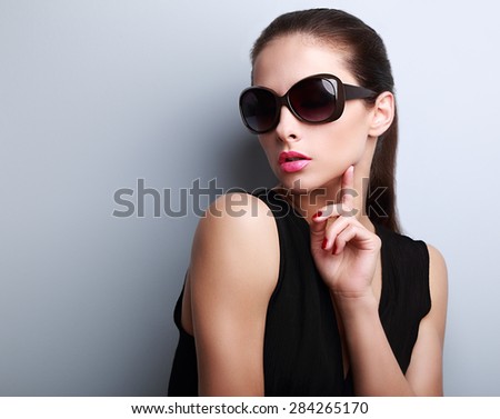 Sexy elegant beautiful female model in fashion sunglasses touching hand the face