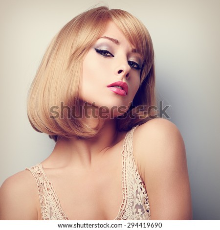 Beautiful blond woman with short hairstyle posing and looking sexy. Color closeup portrait