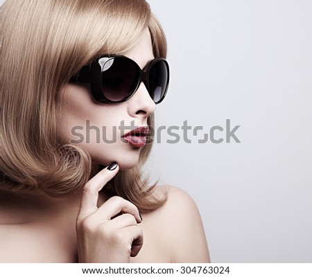Trendy model profile in fashion sunglasses with blond short hairstyle looking. Toned color closeup portrait with empty space