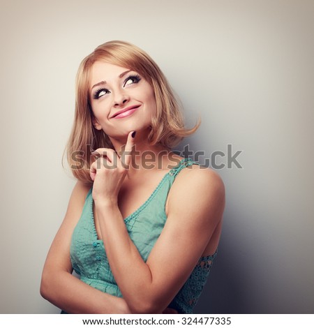 Cute thinking happy woman looking up with natural emotion and casual clothing. Portrait with empty copy space