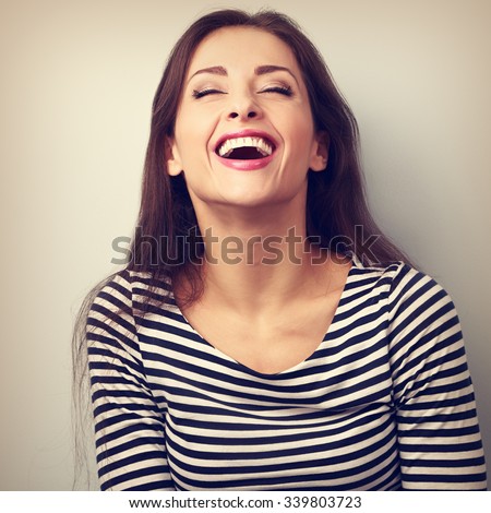 Happy natural laughing young casual woman with wide open mouth and closed eyes. Vintage closeup portrait