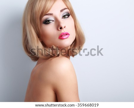 Beautiful glamour makeup woman with long lashes and pink lipstick. Short hairstyle and clean skin. Closeup portrait on blue background